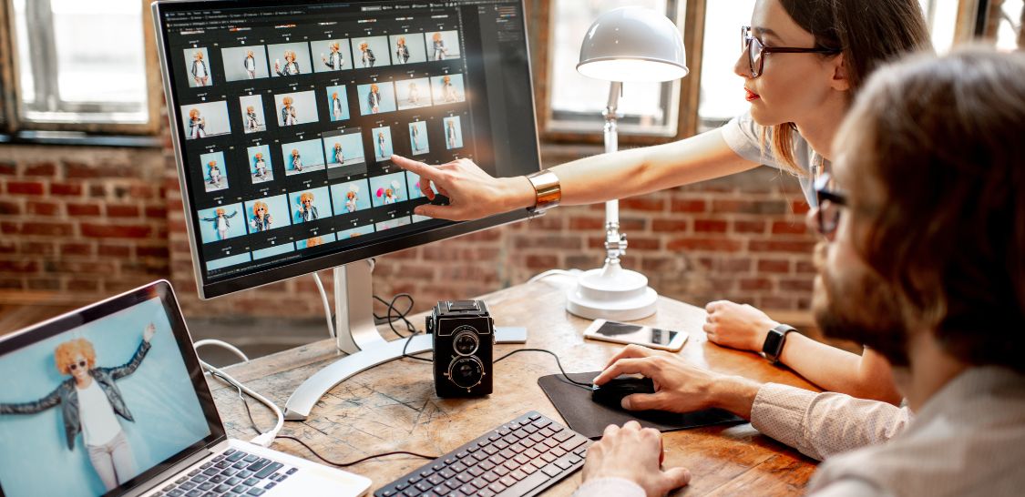 design agency workers pointing at a computer screen working with clients