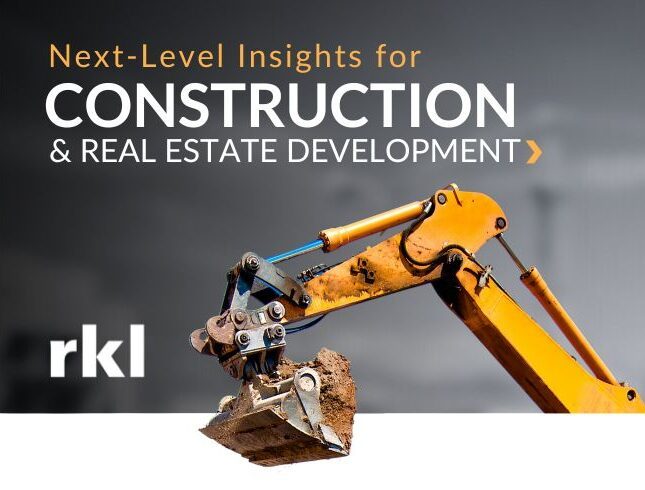A bulldozer arm with dirt in the bucket on a gray background with the words "Next-Level Insights for Construction and Real Estate Development at the top