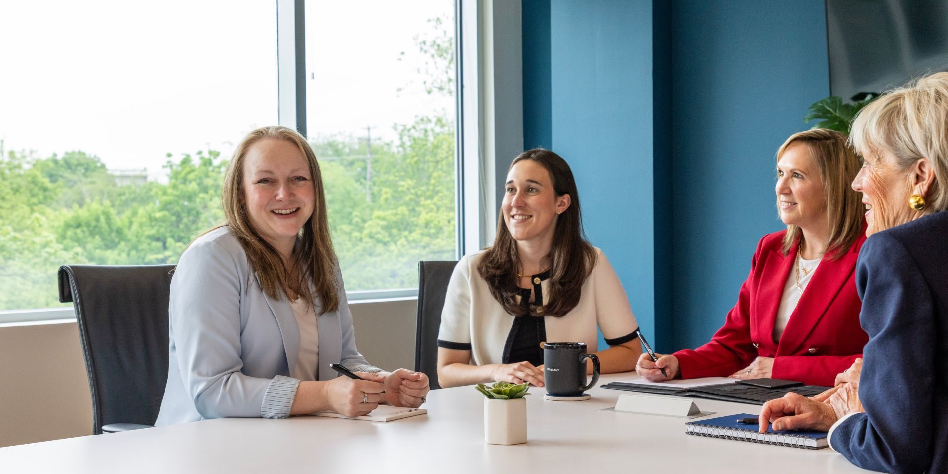 four women at a conference table discussing nonprofit advisory service offerings