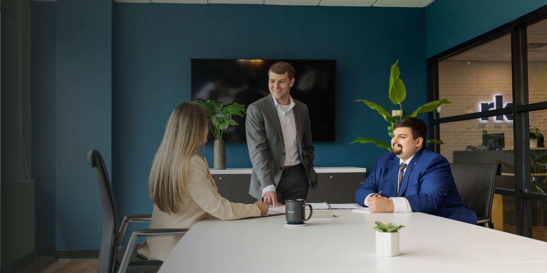 Three tax professionals discussing state and local tax strategies in a modern conference room.