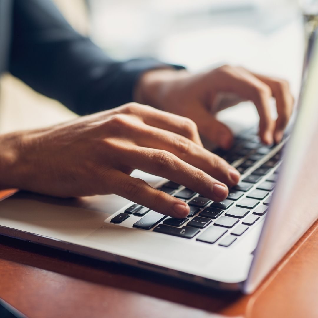 Tax professional typing on a laptop while researching state and local tax matters.